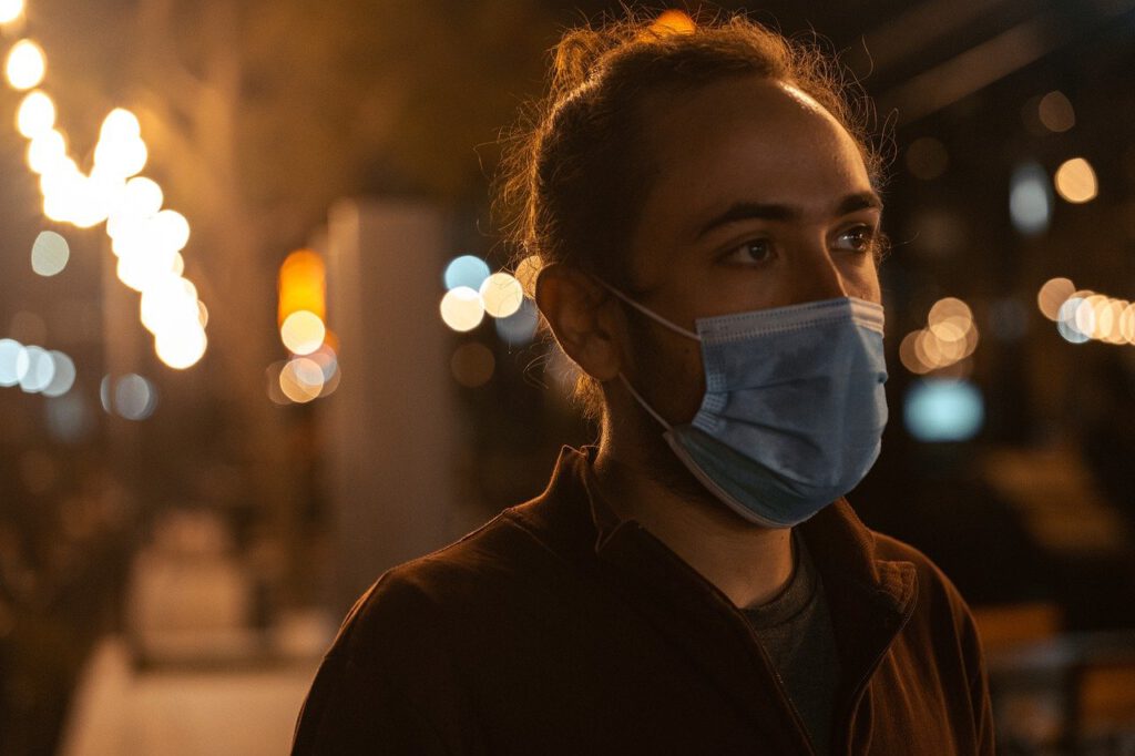 Junger Mann mit OP-Maske im Gesicht